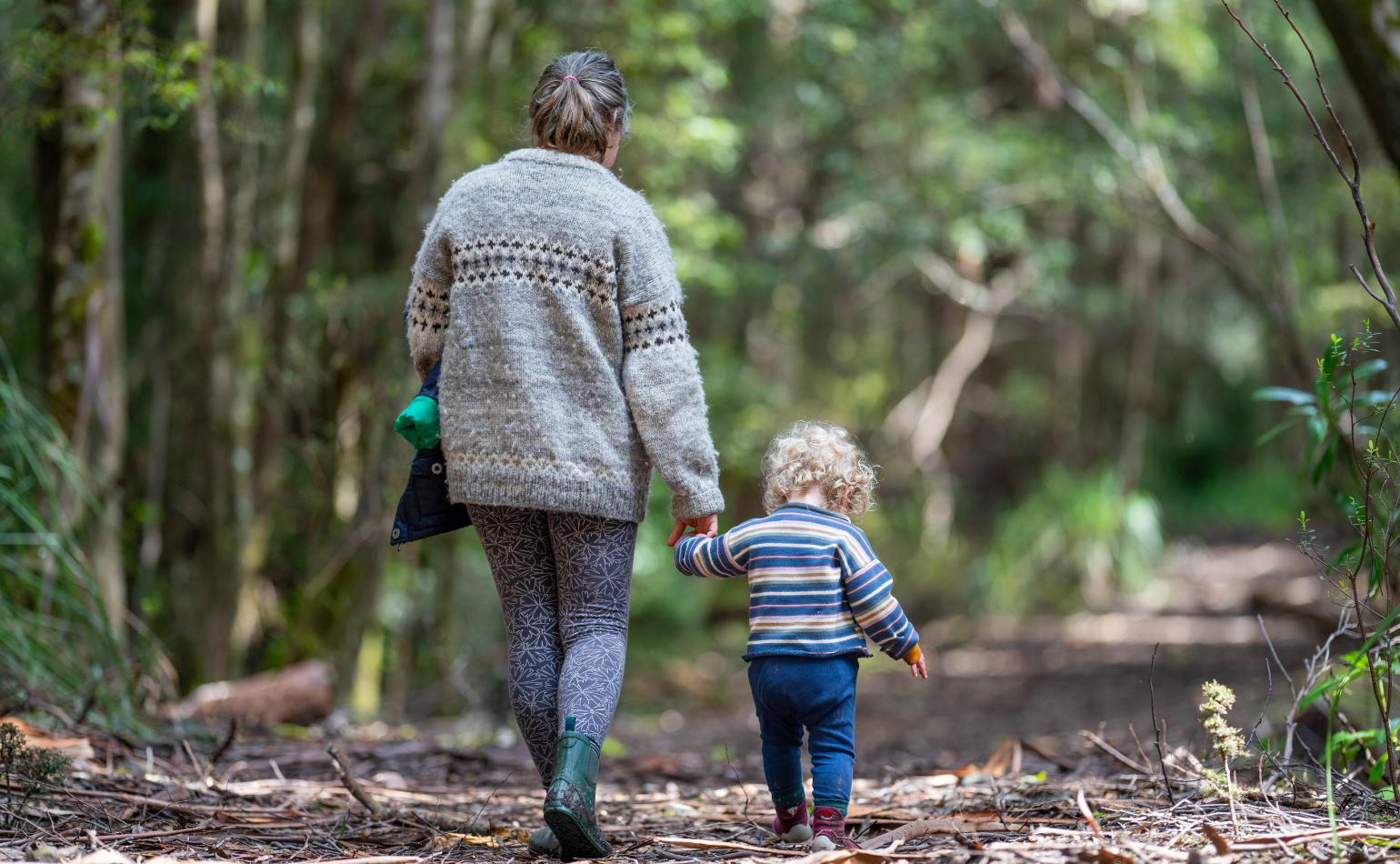 Woman walking her child in the Australian bush