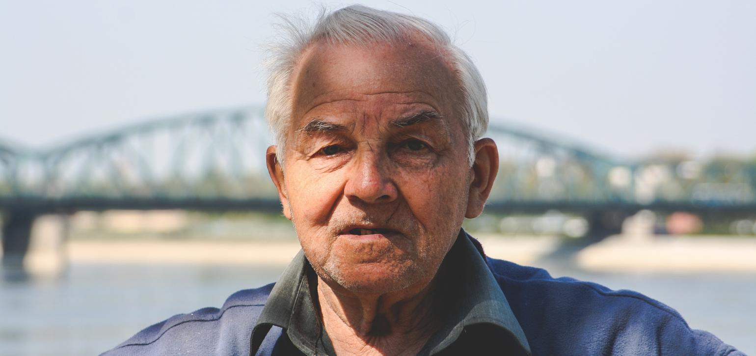 old man with a bridge in background