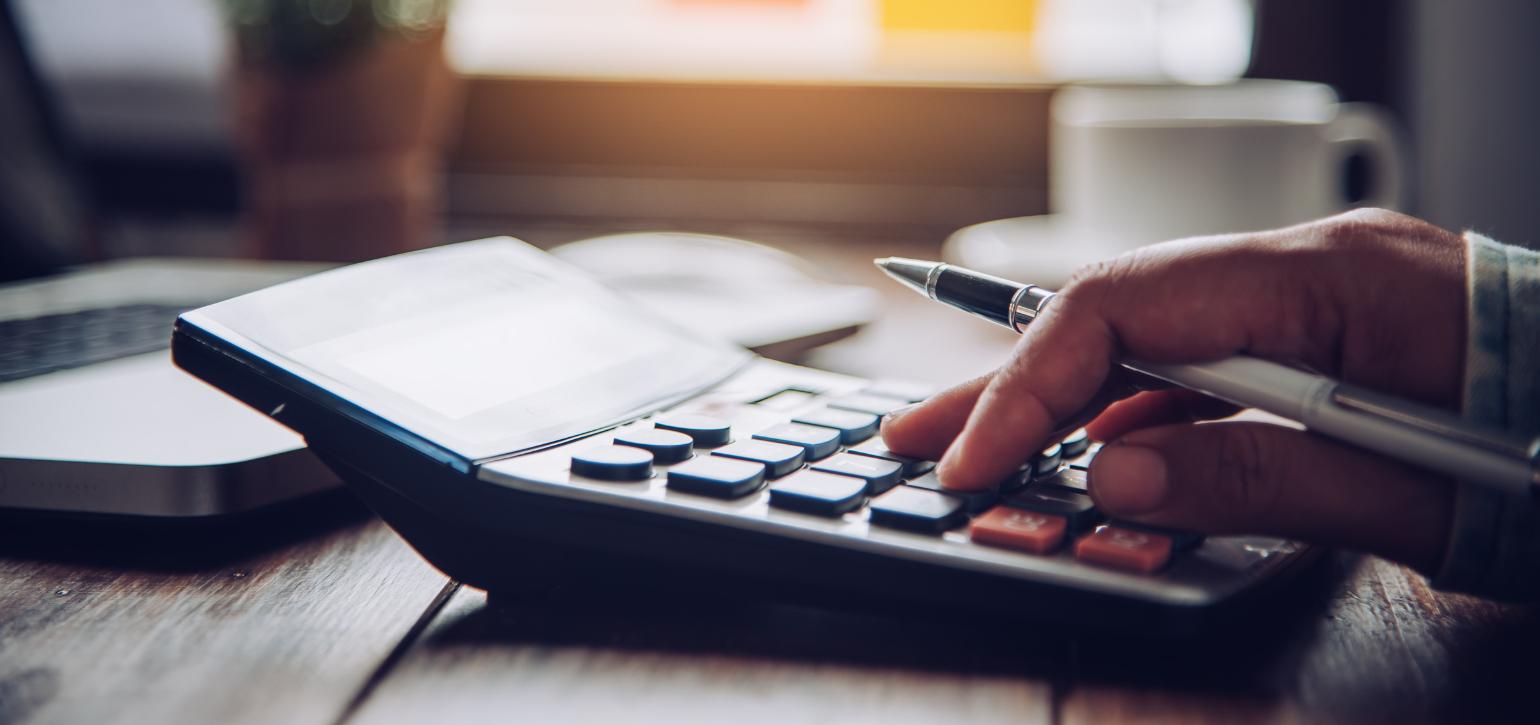 calculator on a desk with hand