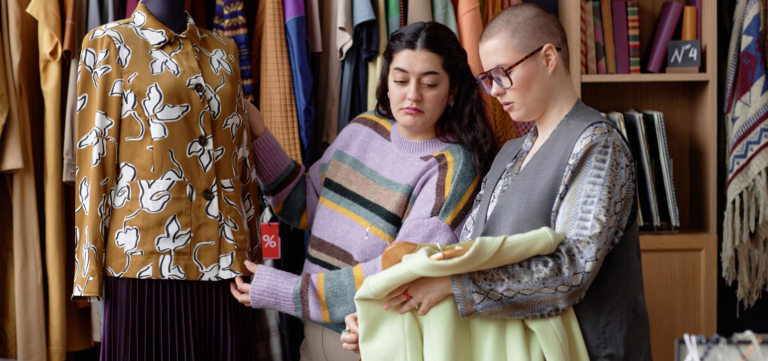 two people looking at clothes in an op shop