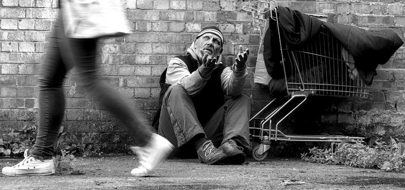 person walking past a homeless person