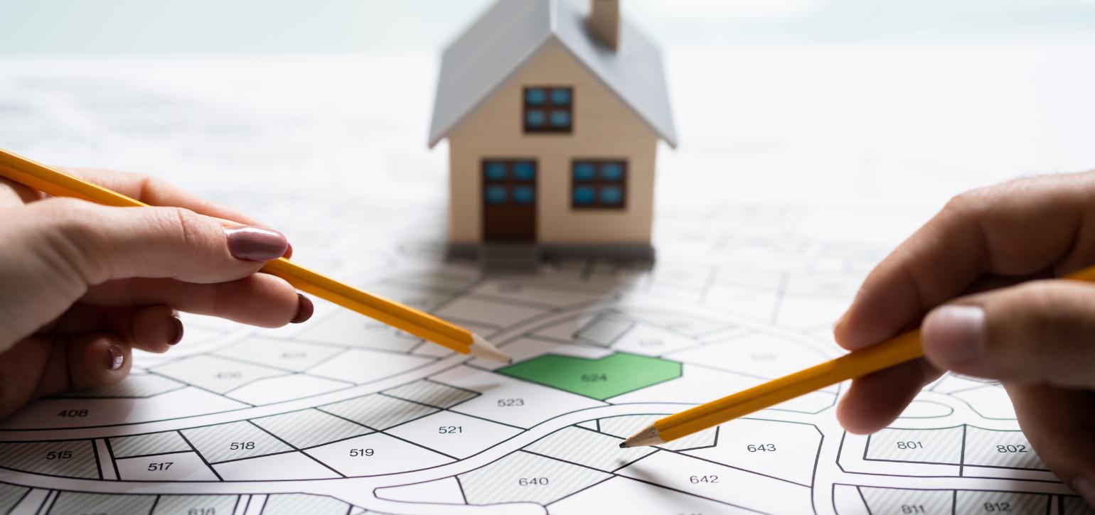 planning maps with pencils and a house prop