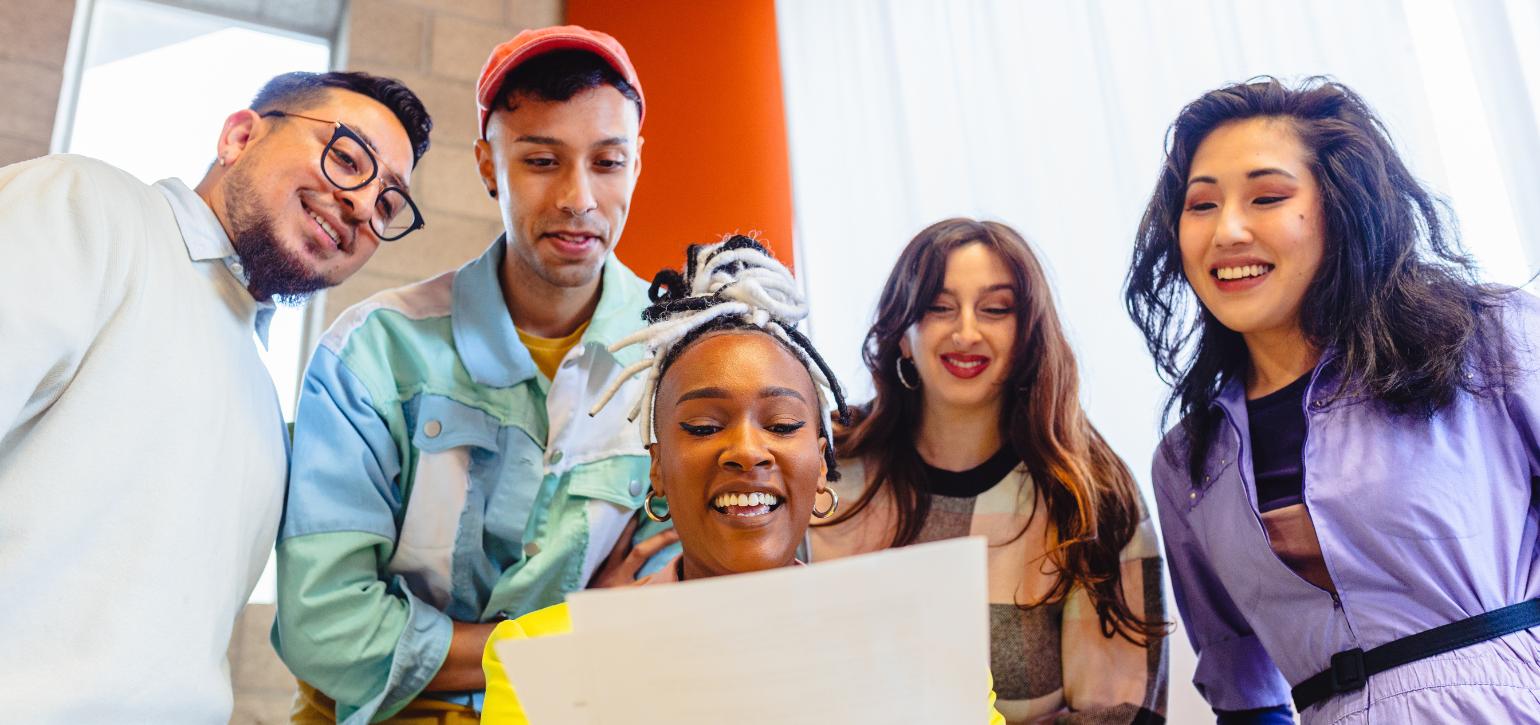 people in a group looking at a laptop