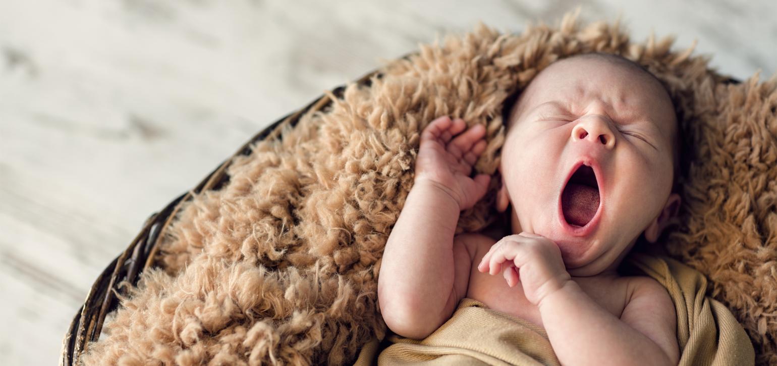baby in a blanket yawning