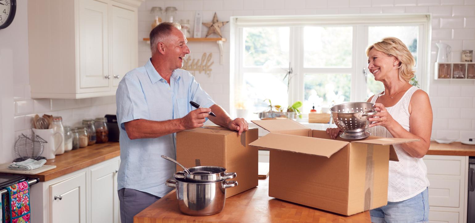 Older couple holding moving boxes
