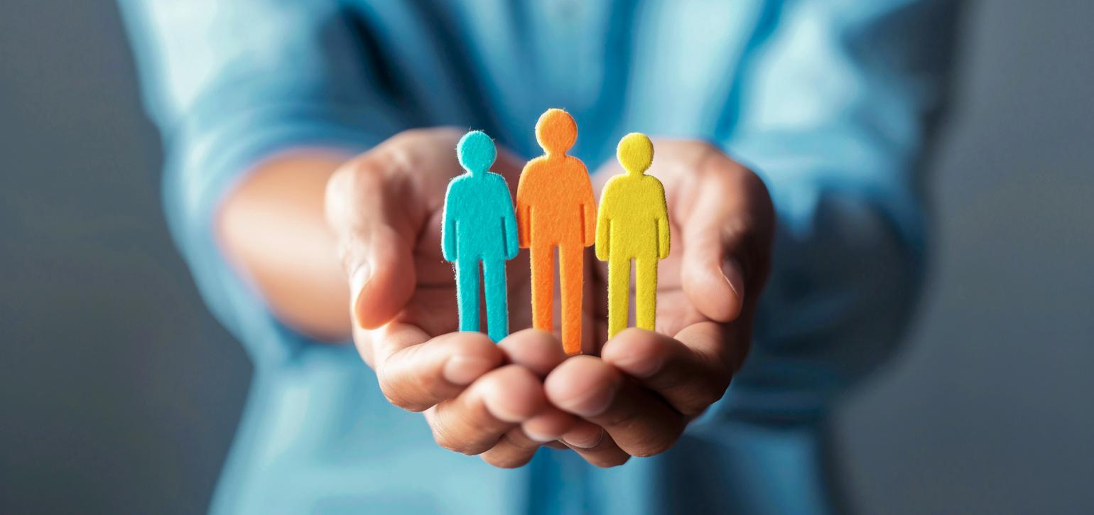hands holding wooden figurines