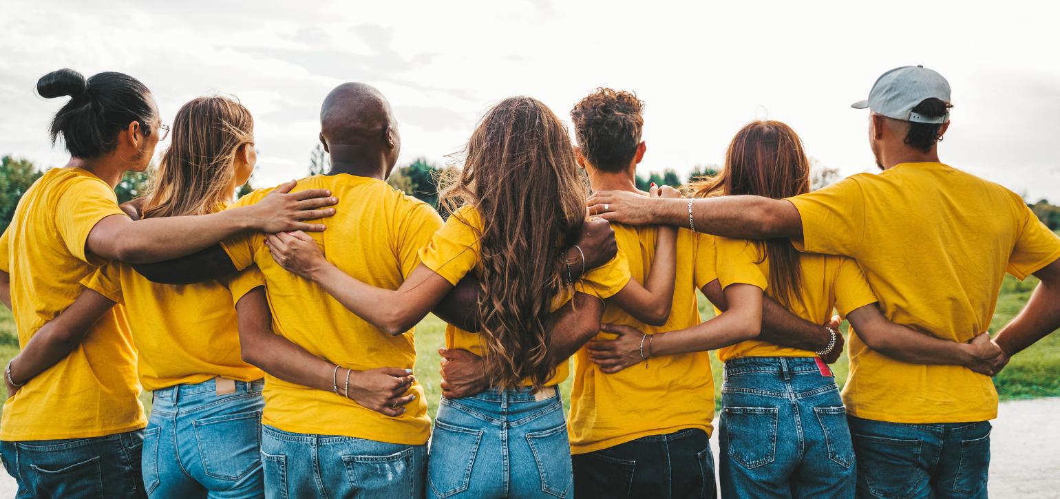 People in yellow T shirts standing arm in arm