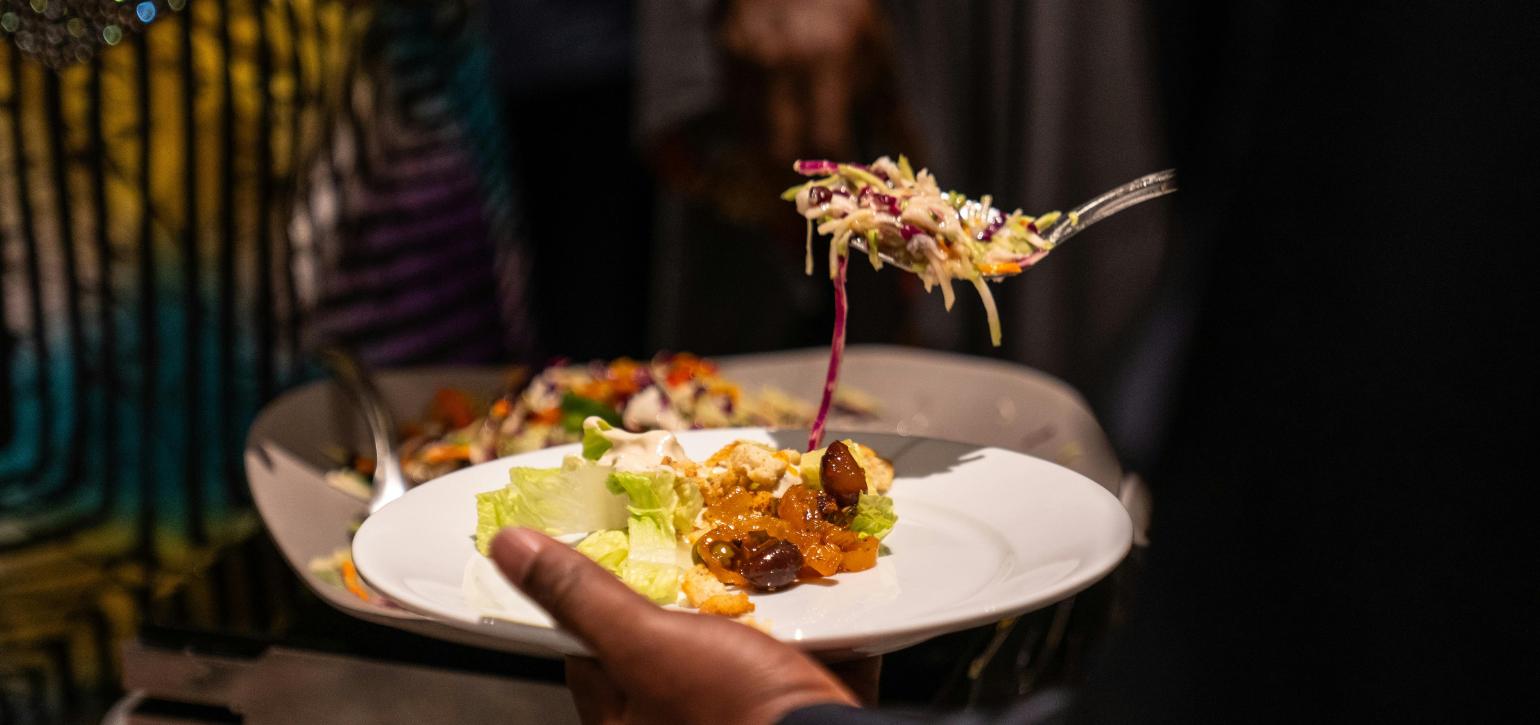 Spooning food from a buffet onto a plate