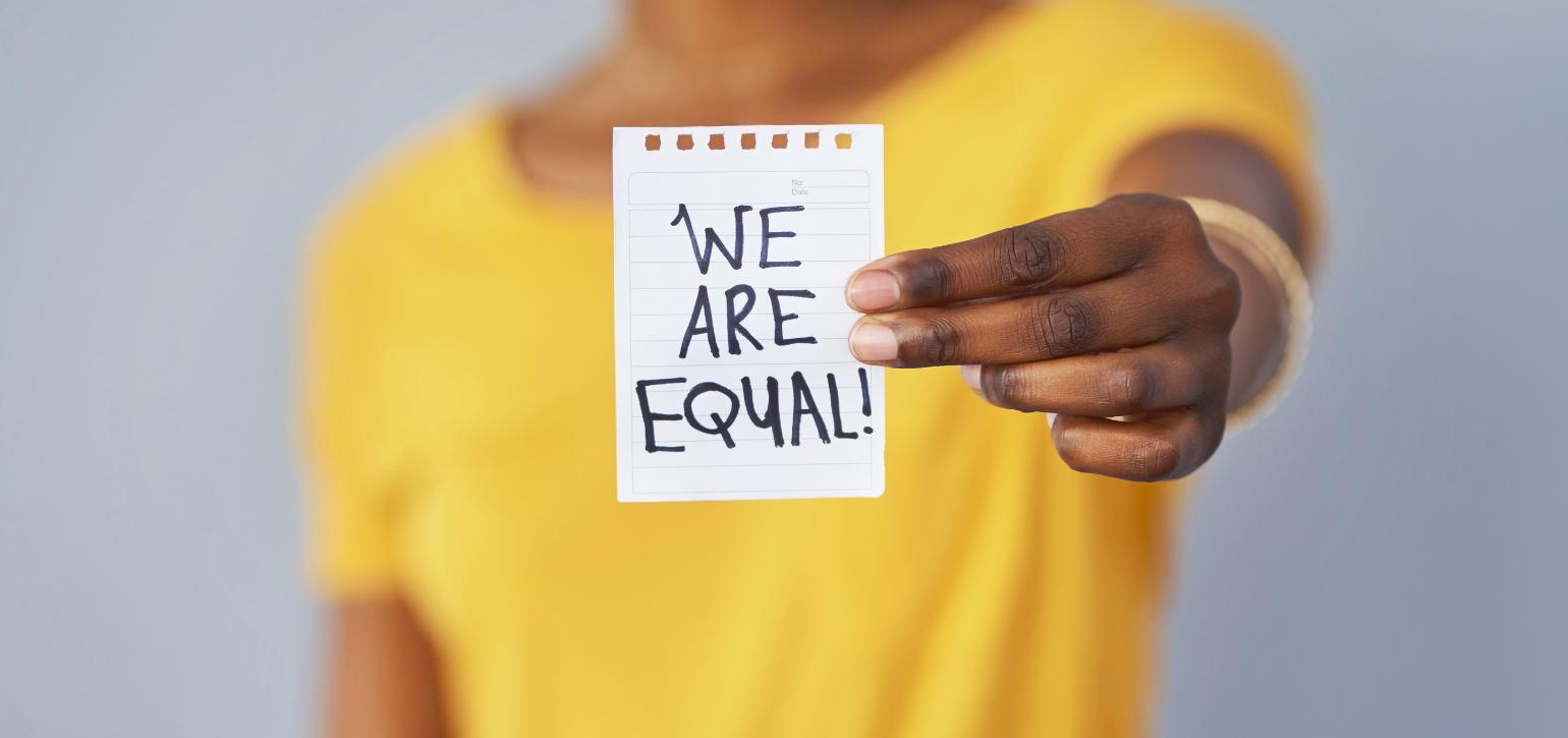 woman in yellow t shirt holding a sign