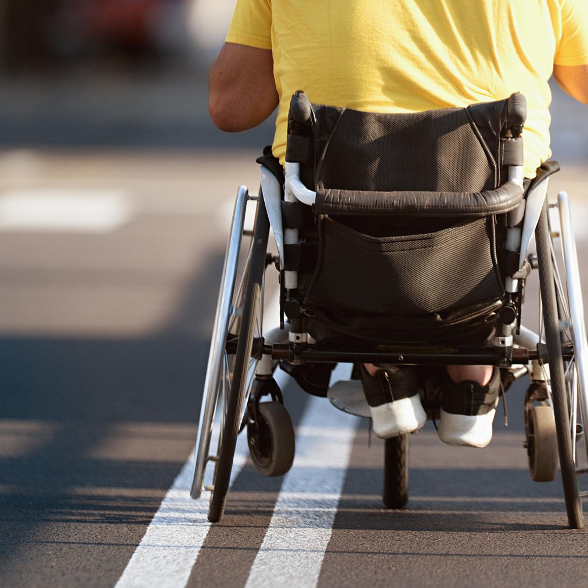 Man in wheelchair wearing yellow t shirt