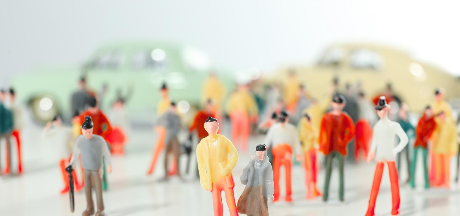 Model figures of people with blurred cars behind