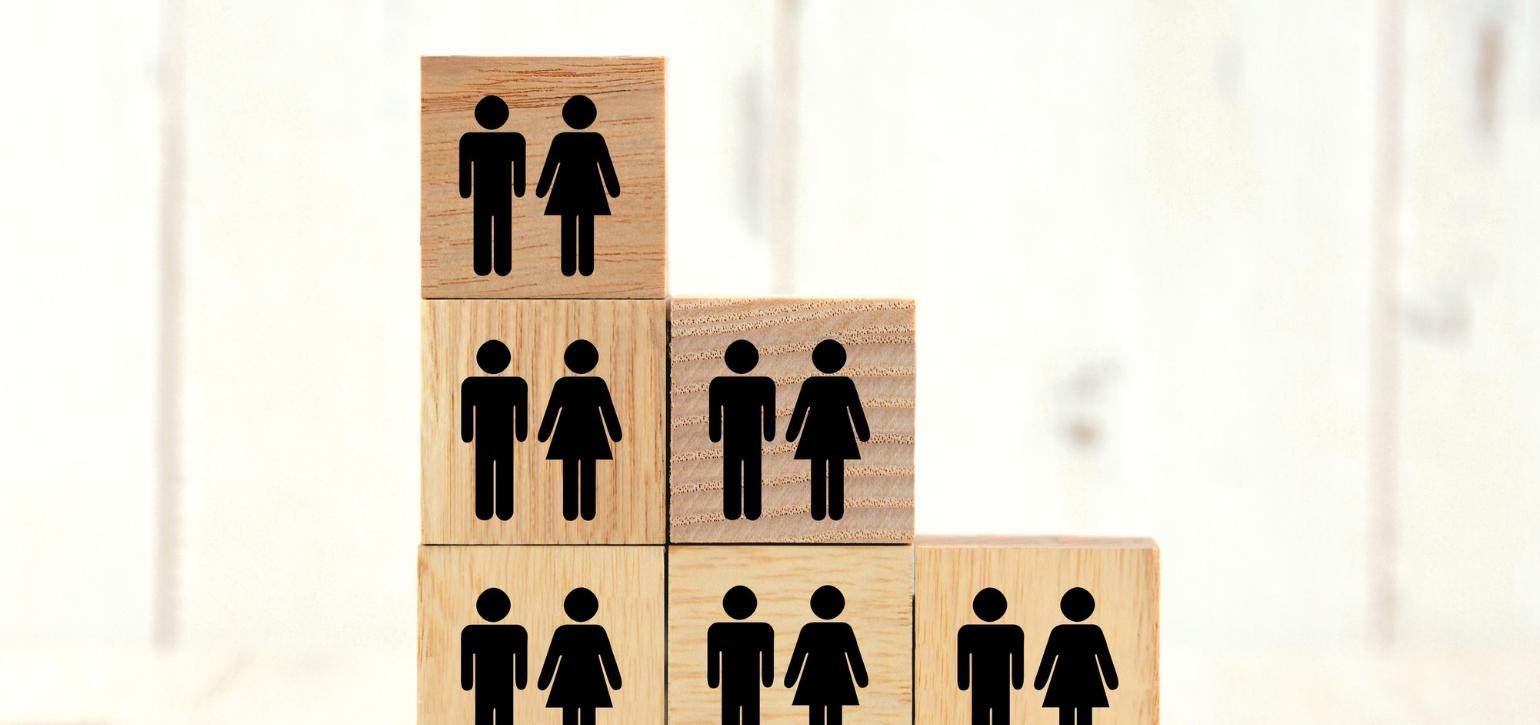 wooden cubes with male and female icons painted in black stacked