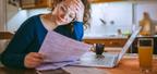 woman looking at bills with a laptop