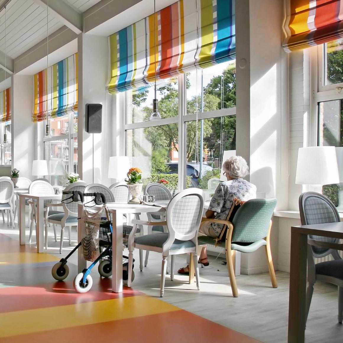 Elderly woman sits alone in an aged care facility.